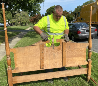 Photo of Bel Air DPW worker Warren Weidner picking up a bed frame